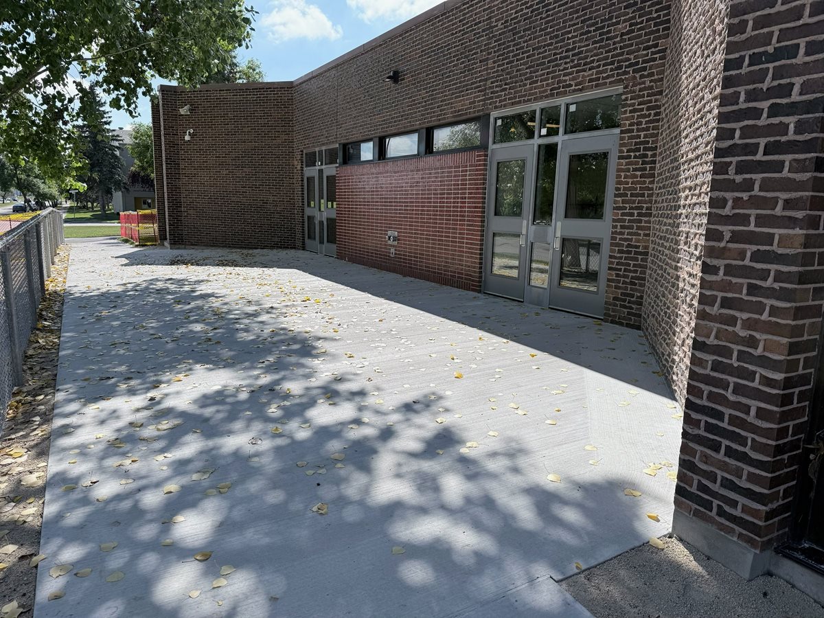 Redeveloped east entry at Chancellor School with new concrete, doors, and fencing