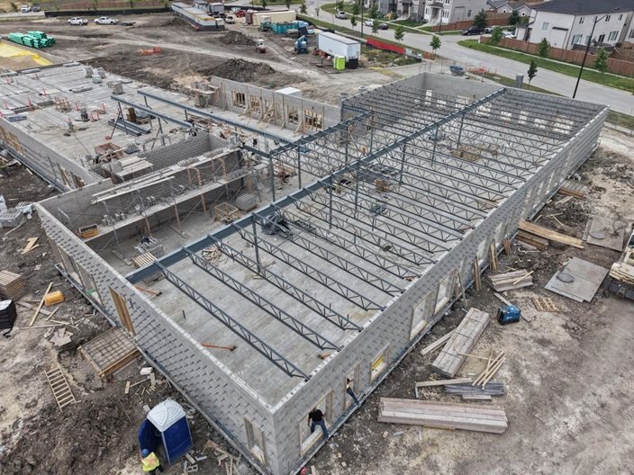 École Iskonakwa School construction site. Structure is starting to take shape with brick walls going up and beams being set in place.
