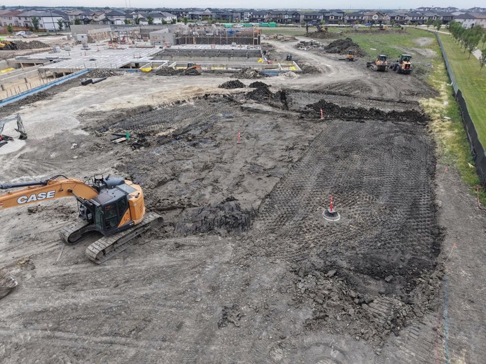 École Iskonakwa School construction site. Excavator digs out site of future parking lot. 